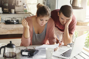 Young married couple looking at the financial differences between buying a home or building a custom home