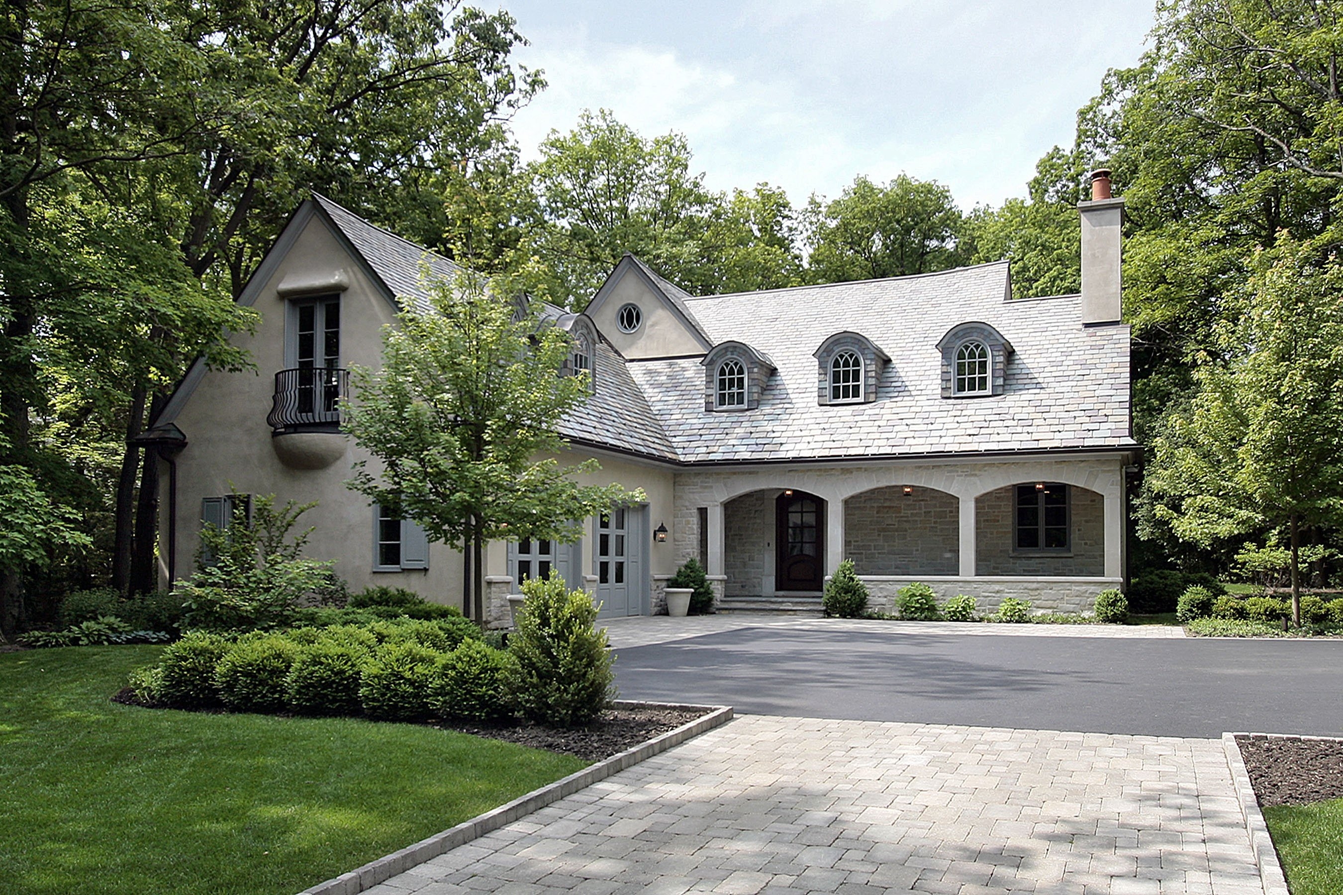 Newly built custom home with large driveway and wooded backyard