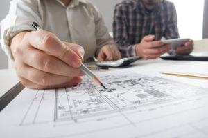 Two floor plan designers draft custom home plans for a client