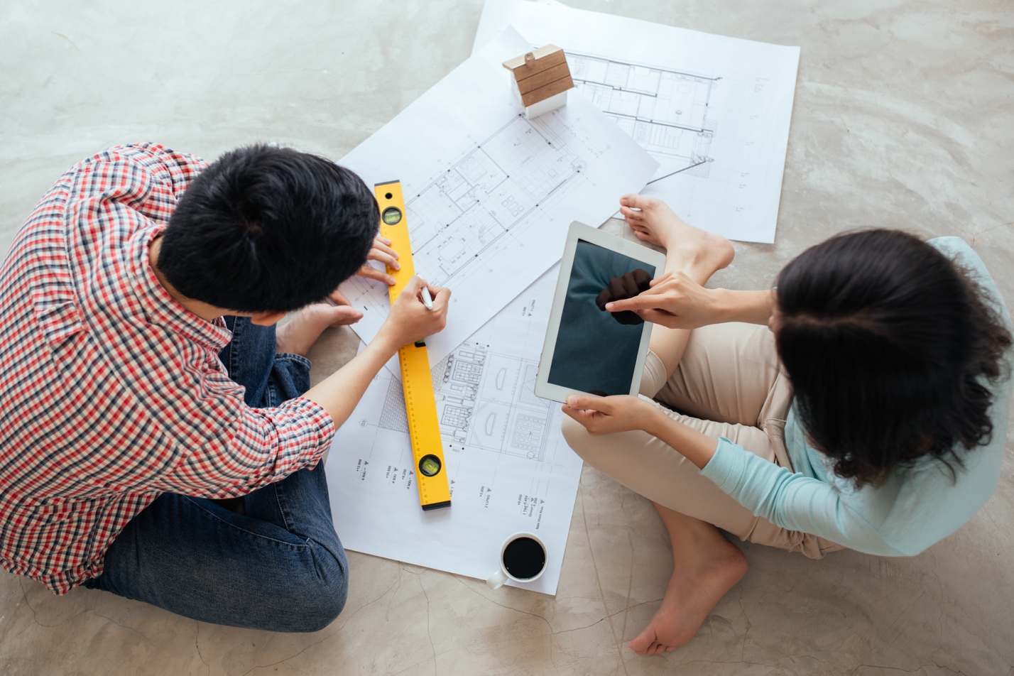 Couple looking at blueprints and drawing up tentative plans for building a home addition